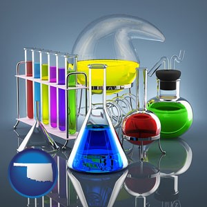colorful chemicals in chemical laboratory vessels - with Oklahoma icon